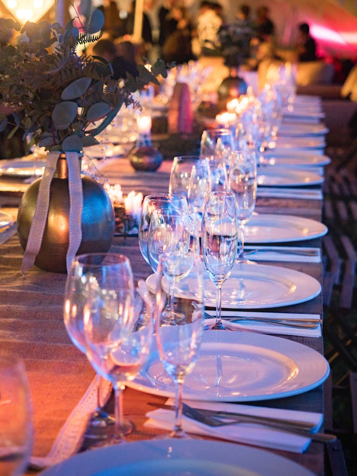 team-03 A beautifully set dinner table with candles and glassware, perfect for elegant events.